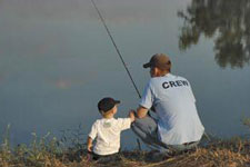 Man and boy fishing on shore of Norfork Lake