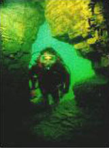 Diver underwater in cave opening