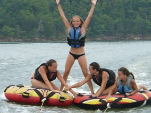 Girls do tricks while tubing on lake