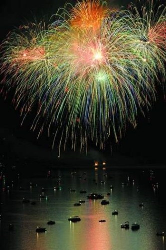 Boat on Norfork Lake with fireworks overhead