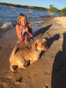 Girl and dog on Norfork Lake sandy beach