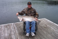 Man in wheelchair with striped bass fish