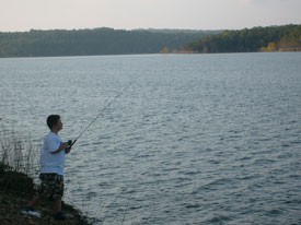 Man fishing on shore Norfork Lake