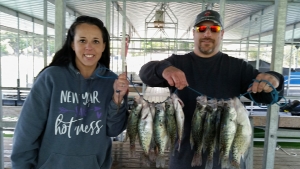 Man and woman with large stringer of crappie.